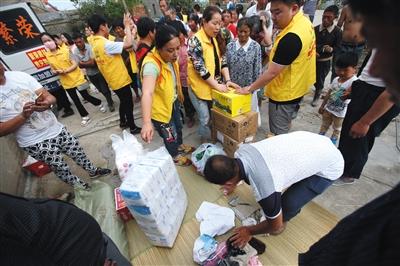 6月24日，新涂村，志愿者为村民发放日用品。
