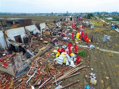 6月24日，阜宁县大楼村的房屋几乎被夷为平地，救援人员在帮助村民清理房屋。